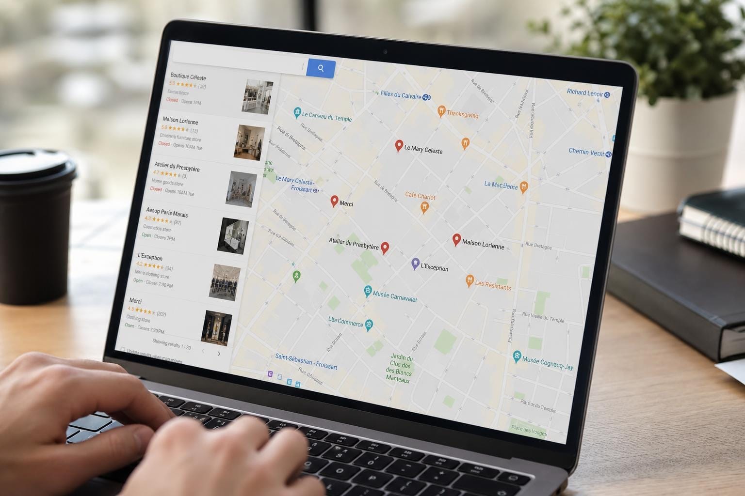 Écran d'ordinateur affichant une carte Google Maps avec des épingles de commerces locaux dans une rue commerçante