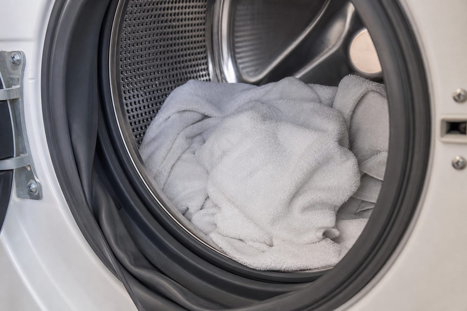Intérieur d'un tambour de lave-linge ouvert avec le joint en caoutchouc de la porte visible en gros plan