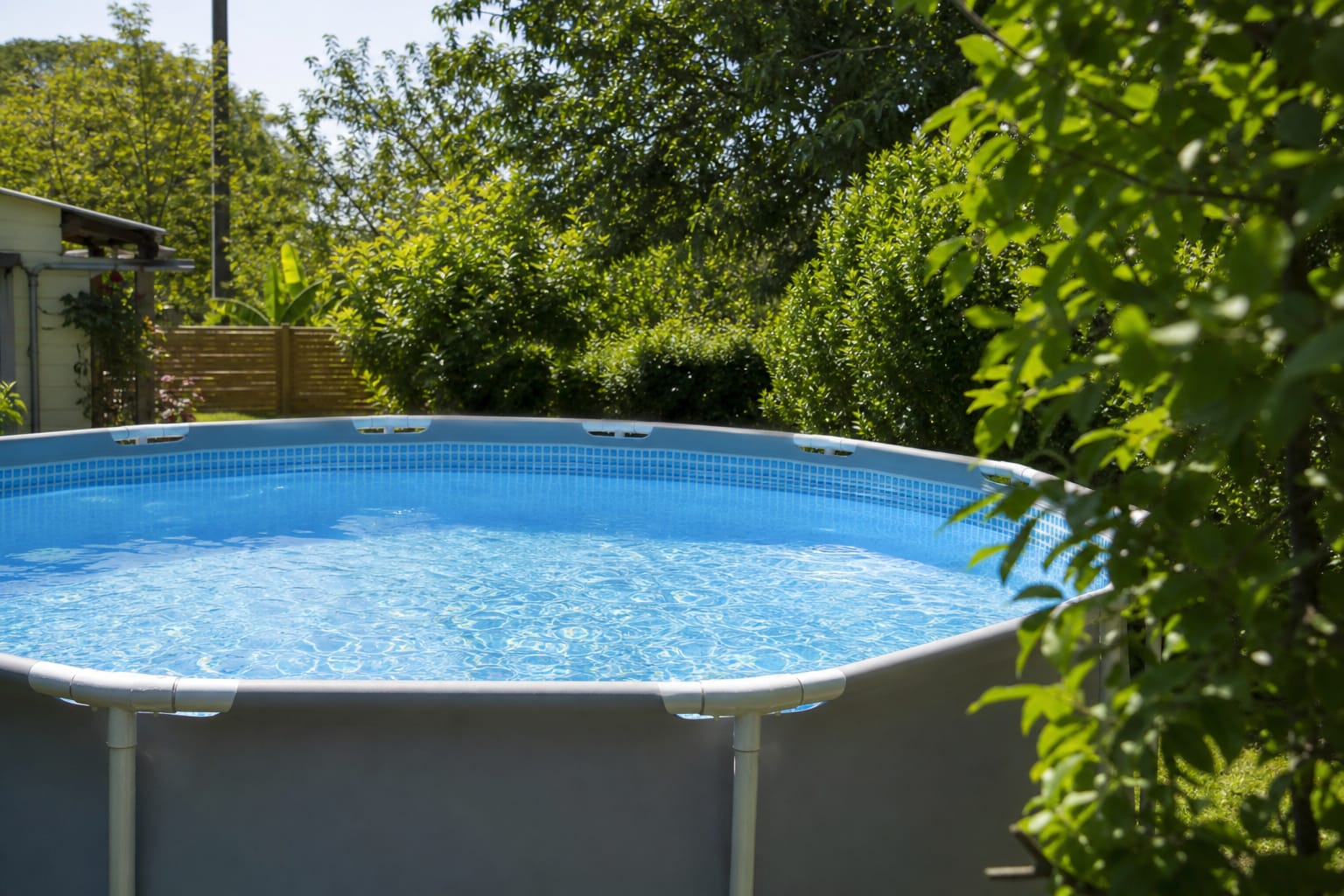 Piscine hors-sol dans un jardin, niveau d'eau visible contre la paroi, marquage de mesure improvisé au ruban adhésif